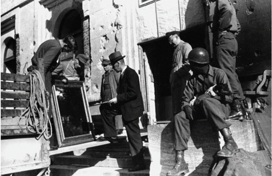 Schwarzweißfotografie. Gerahmtes Gemälde auf Ladefläche eines Lastwagens, Uniformierte.