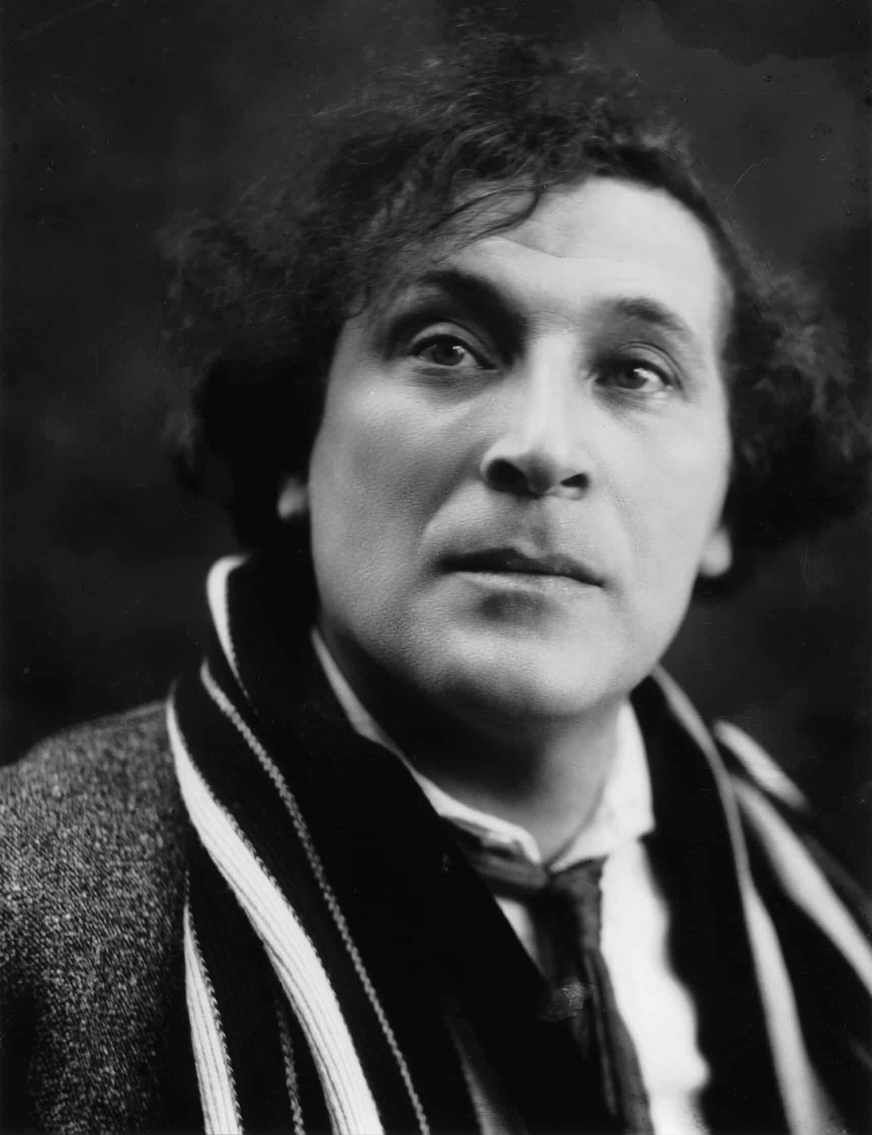 Schwarzweißfotografie. Porträt Marc Chagall, junger Mann mit dunklem lockigen Haar und Schal.