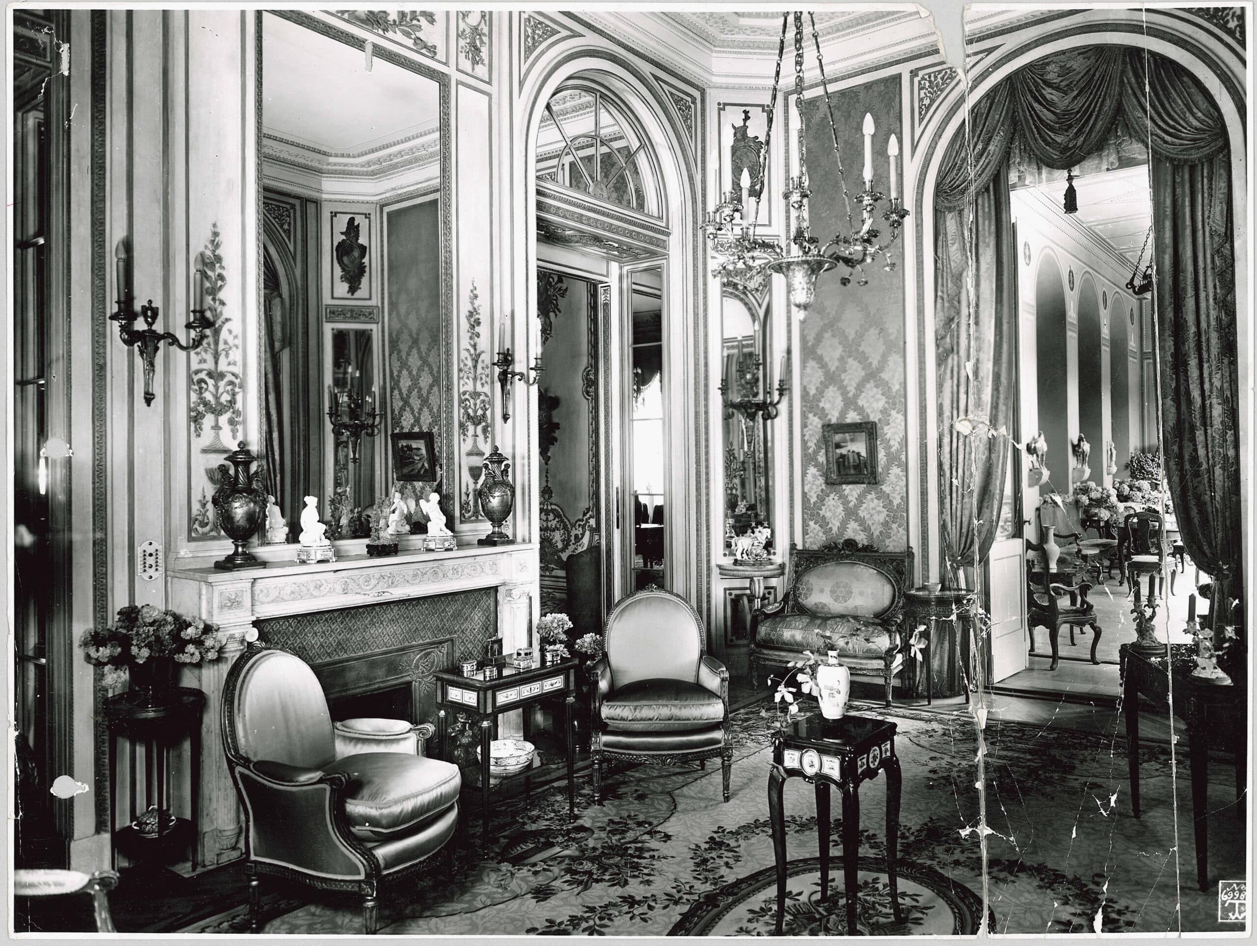 Black and white photography: a room furnished with furniture, wall decorations and paintings