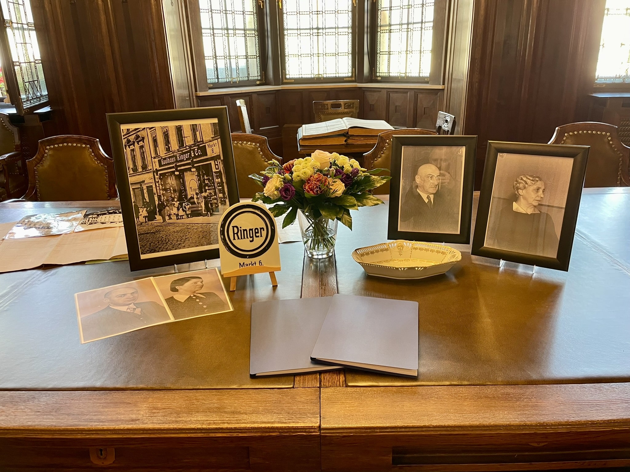 A photograph of various documents and flowers on a table in Werdau Town Hall.